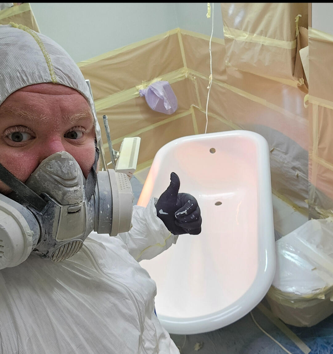 photo of glossy baths owner photo of glossy baths re-enamelling owner Seamus with a thumbs up, in ppe, in a room full of masking up and a completed bath in Newbury